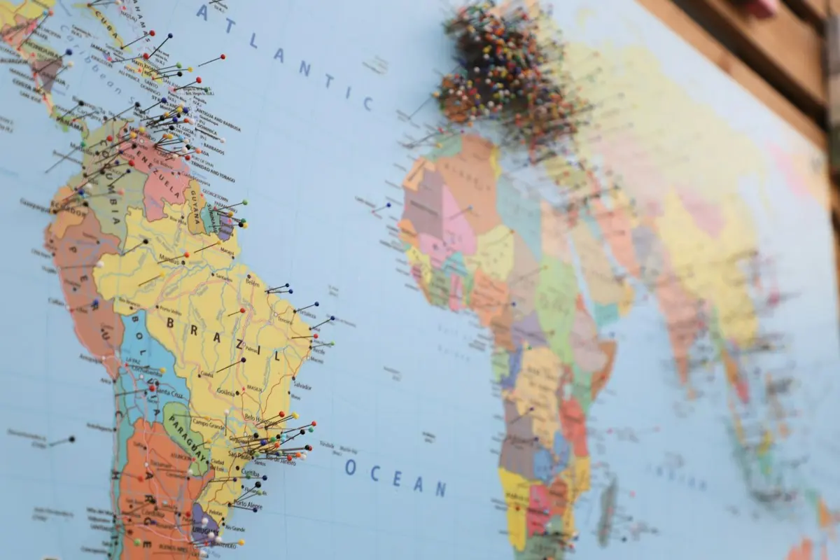 Physical world map marked with location pins