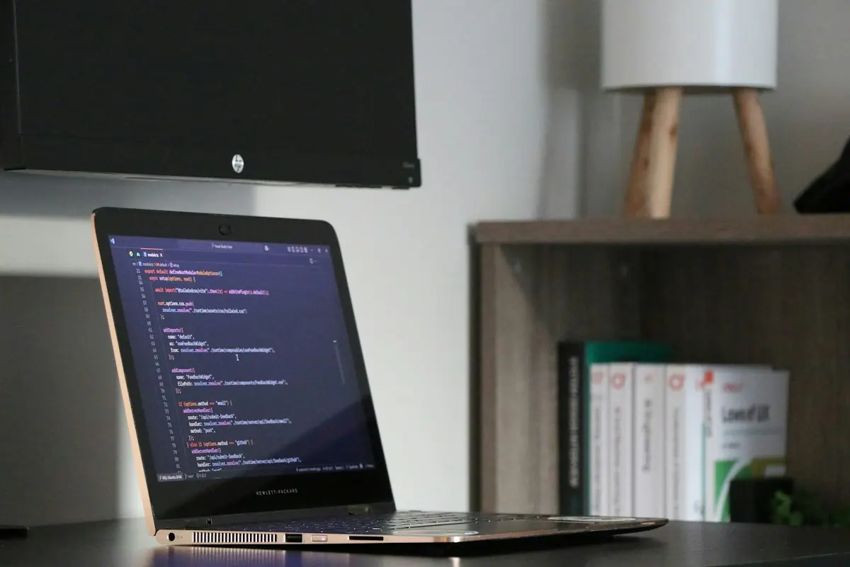 Laptop displaying code on a workspace desk