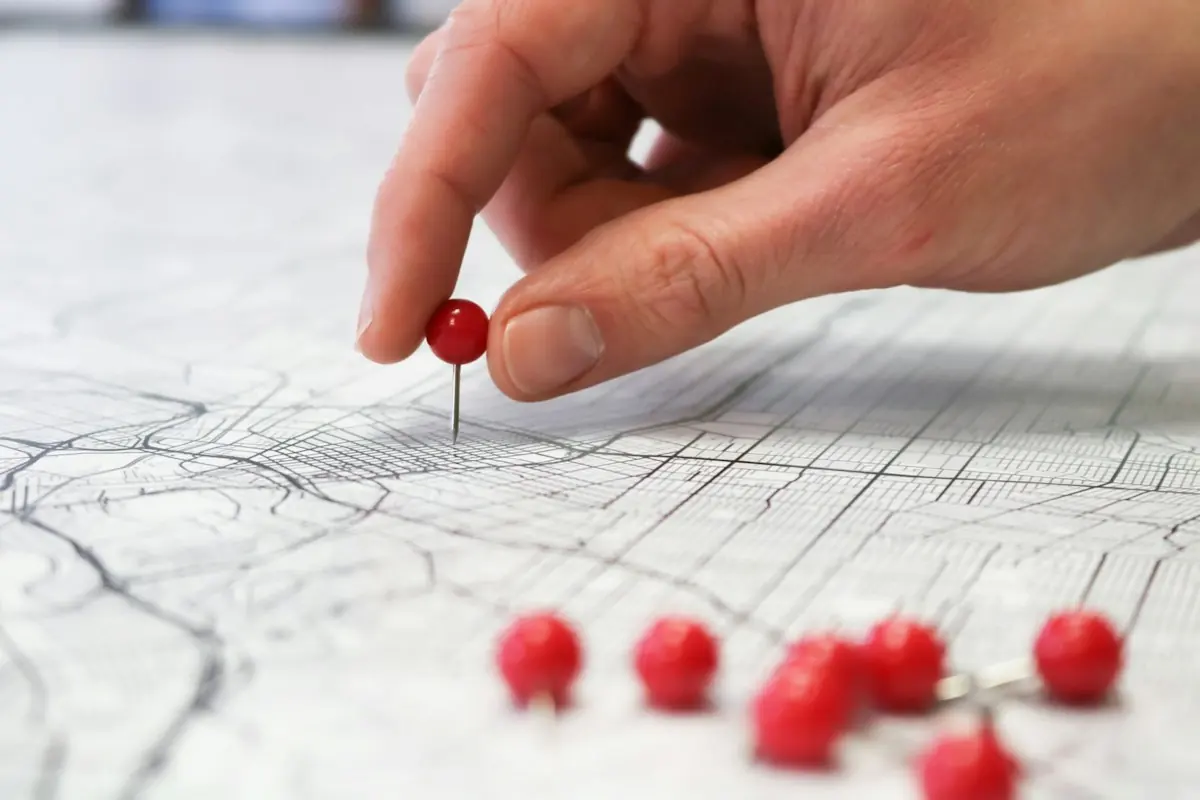 Hand placing a location pin on a city street map