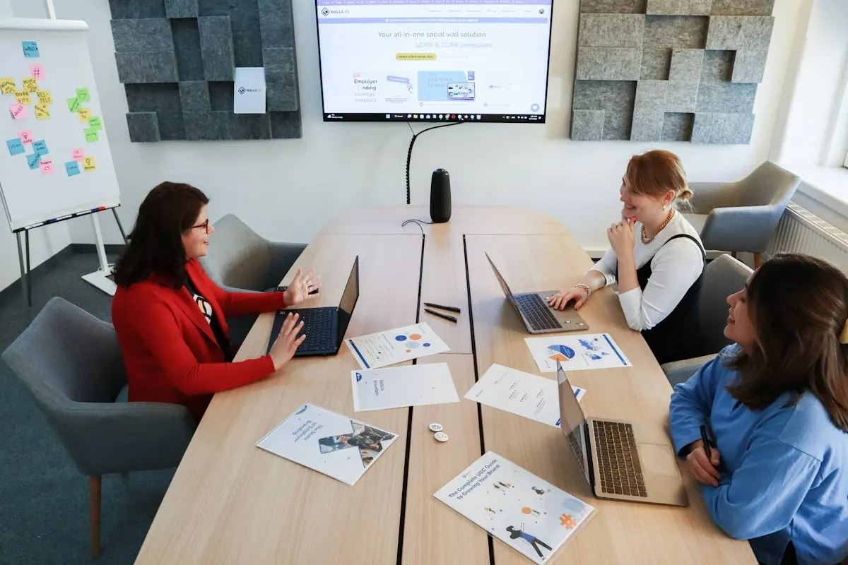 Marketing team meeting around a table with laptops
