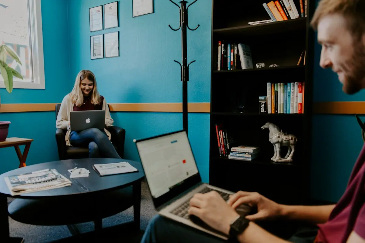Smiling professional collaborating with colleagues over a laptop